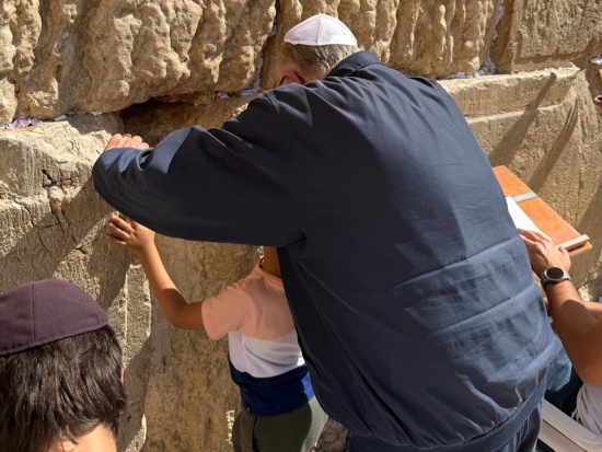 A person and child touching a rock wall