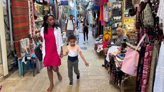 A person and a child walking in a market