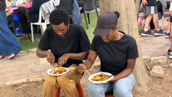 A couple of men sitting outside eating food