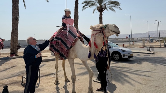 Two people riding a camel