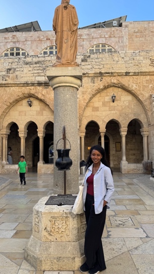 A person standing in front of a stone pillar