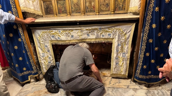 A person kneeling in front of a fireplace