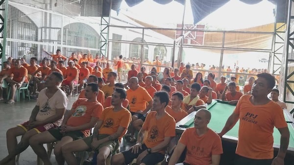 A group of people in orange shirts