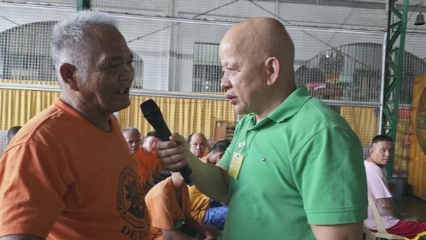 A person holding a microphone to another person