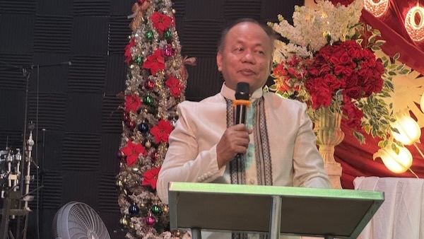 A person standing at a podium holding a microphone