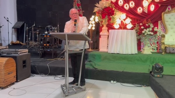 A person standing at a podium with a microphone