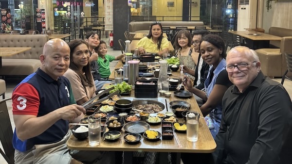 A group of people sitting at a table with food on it
