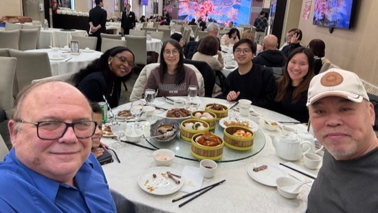 A group of people sitting at a table with food