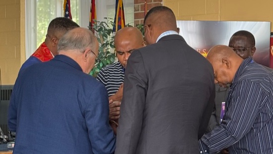 A group of men standing in a circle

Description automatically generated