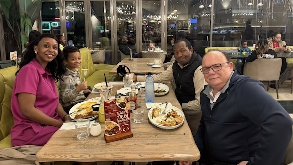 A group of people sitting at a table with food