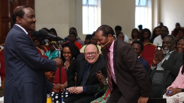 A person in a suit laughing at a person in a suit