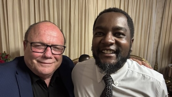 Two men sitting together smiling
