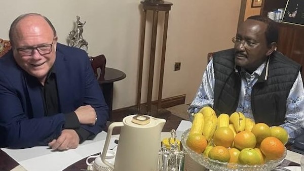 A group of men sitting at a table with fruit