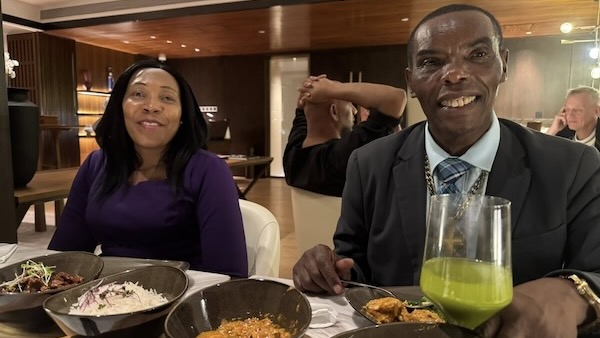 A person and person sitting at a table with food