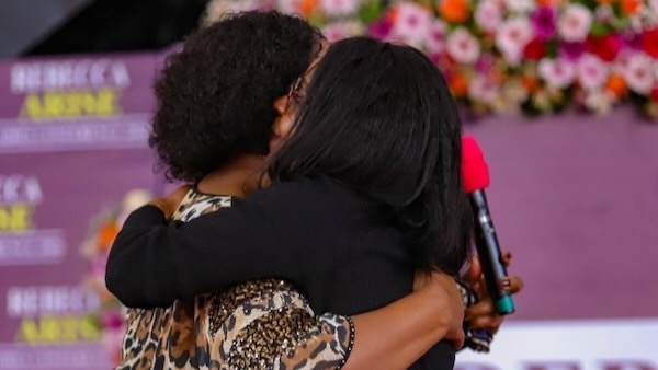 A person hugging another person