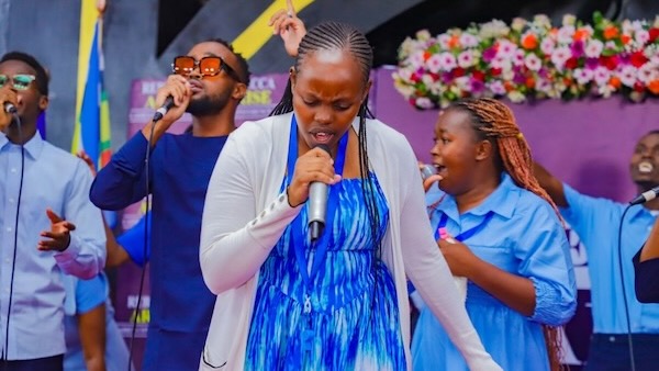 A group of people singing into a microphone