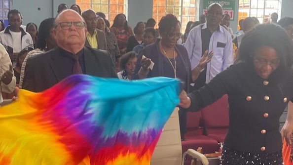 A person holding a tie dye fabric