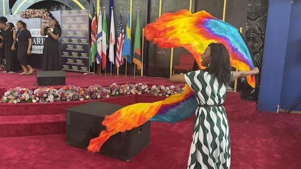 A person standing in front of a podium with a colorful fabric