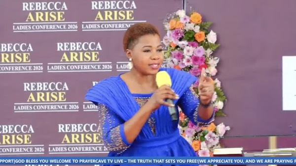 A person in a blue dress holding a microphone