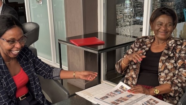 A person sitting at a table with a newspaper