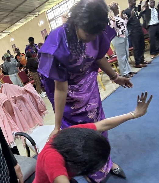 A person in a purple dress kneeling on a chair