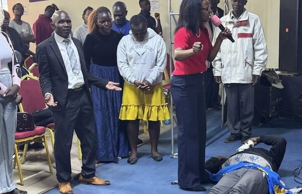 A group of people standing around a person lying on the ground
