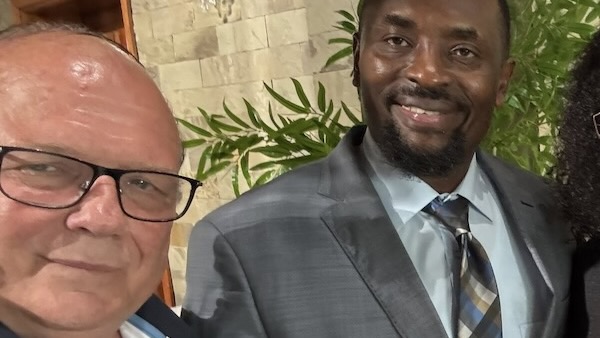 Two men in suits smiling