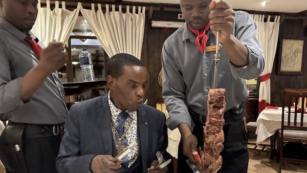A person holding a skewer and another person holding a skewer