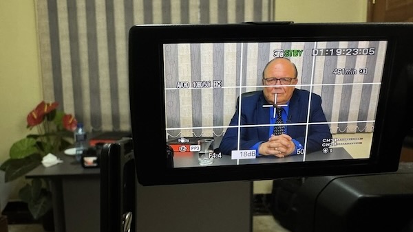 A person in a suit sitting at a table