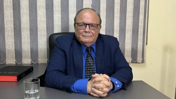 A person in a suit sitting at a desk