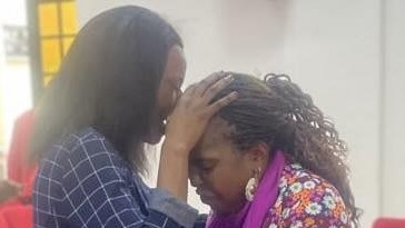A person touching her head with her hand