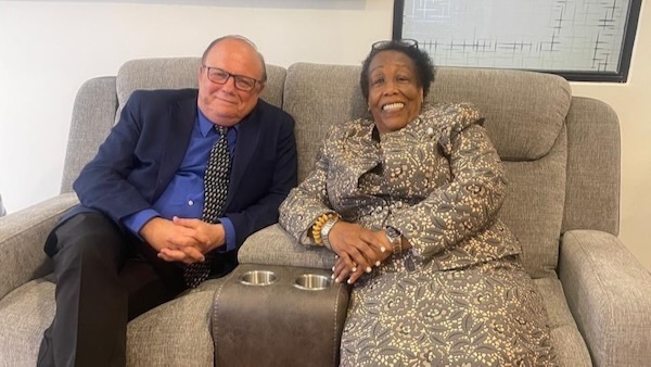 A person and person sitting on a couch