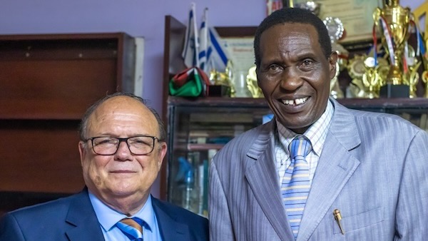 Two men in suits smiling